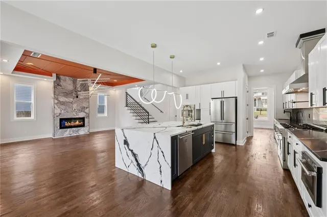 a kitchen with stainless steel appliances granite countertop a stove and a wooden floors