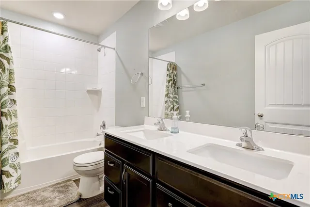a bathroom with a double vanity sink toilet and a bathtub