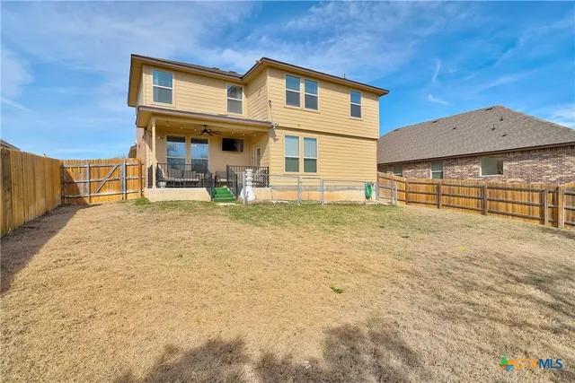 a view of a house with table and chairs under an umbrella