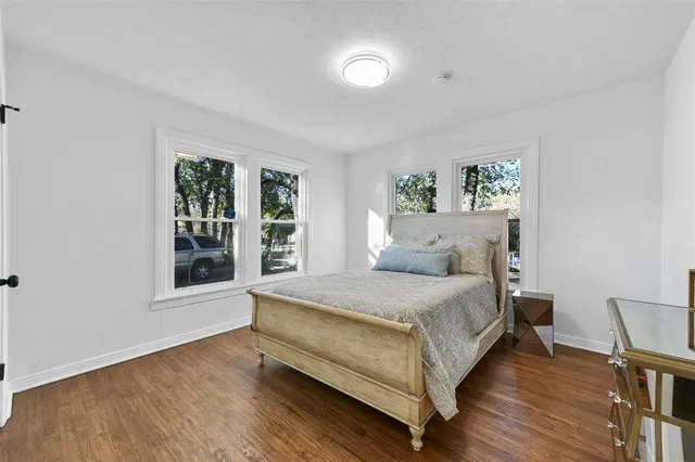 a bed sitting in a spacious bedroom next to a window
