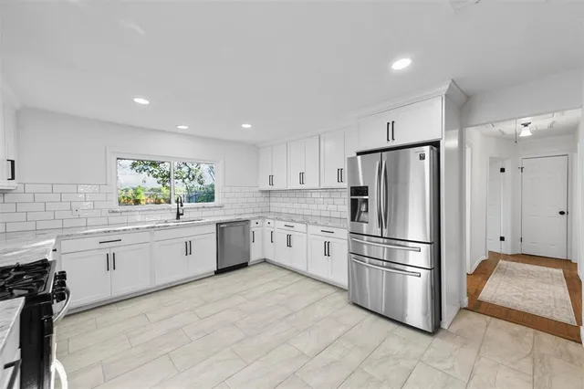 a kitchen with stainless steel appliances a refrigerator sink and cabinets