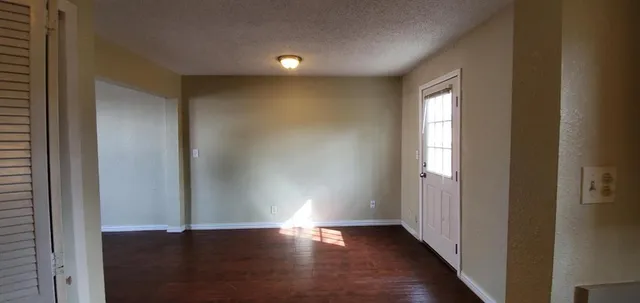 a view of hallway with window and wooden floor