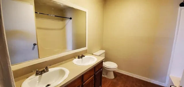 a bathroom with a granite countertop sink toilet and a mirror