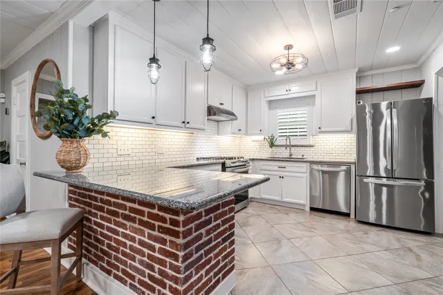 a kitchen with stainless steel appliances granite countertop a stove and cabinets