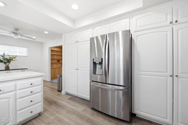 an empty room with windows and ceiling fan