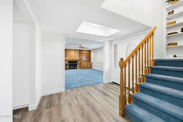 an empty room with windows and ceiling fan