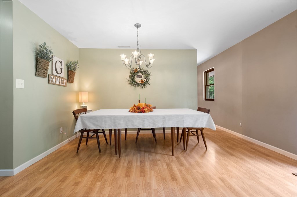 5597 South No Pone Valley Road Decatur, TN 37322 - Photo 22 of 44 a dining room with furniture a chandelier and wooden floor