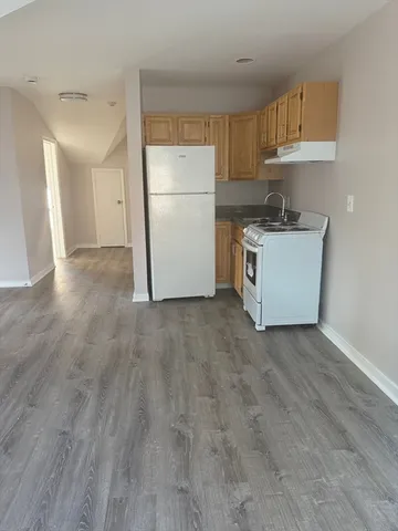 a kitchen with granite countertop a refrigerator and a sink