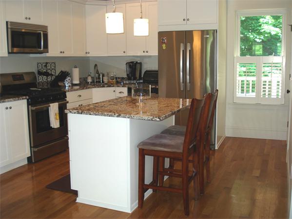 a kitchen with granite countertop a sink a stove a refrigerator a dining table and chairs