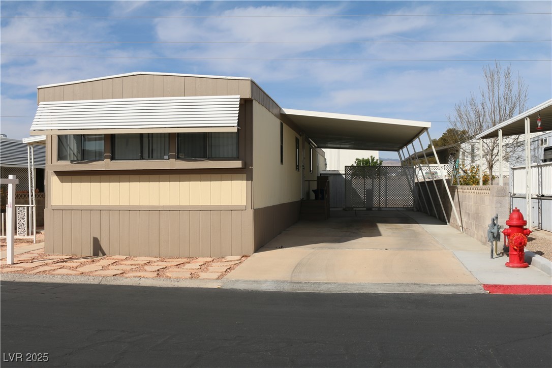 4633 Royal Ridge Boulevard Las Vegas, NV 89103 - Photo 2 of 13 Manufactured / mobile home featuring driveway, fence, and a carport