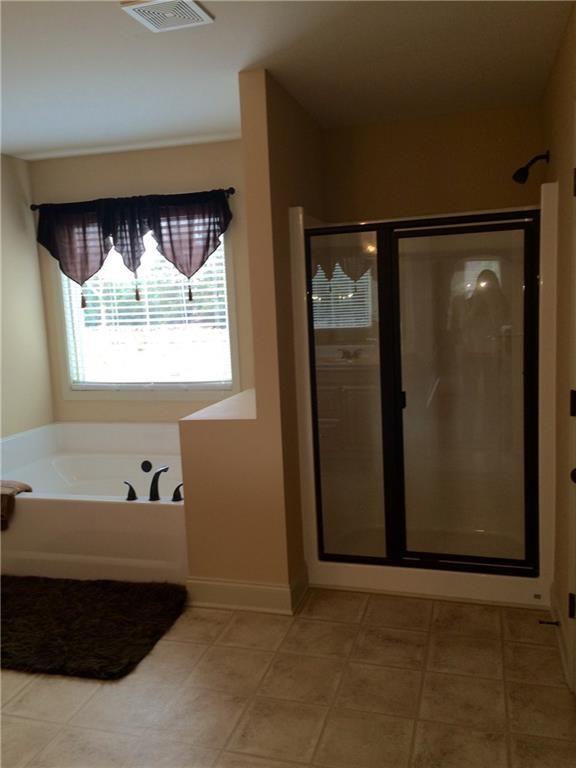 718 Channel Lane Lawrenceville, GA 30046 - Photo 13 of 16 a bathroom with a bathtub and a shower