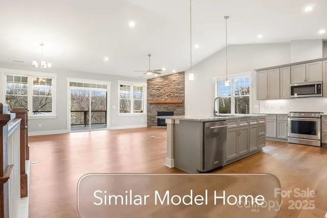 a view of a kitchen with kitchen island a counter top space a sink stainless steel appliances and cabinets