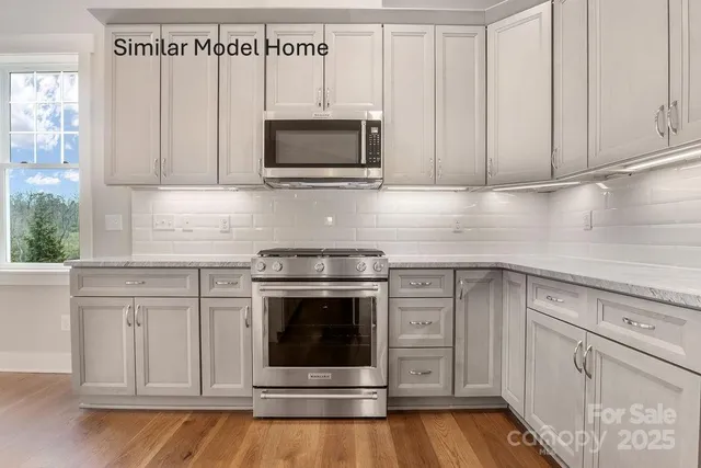 a kitchen with white cabinets stainless steel appliances and sink