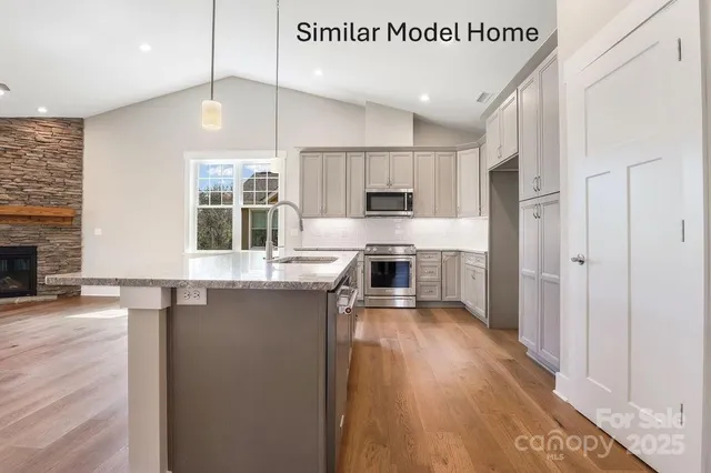 a kitchen with stainless steel appliances a refrigerator and a stove top oven
