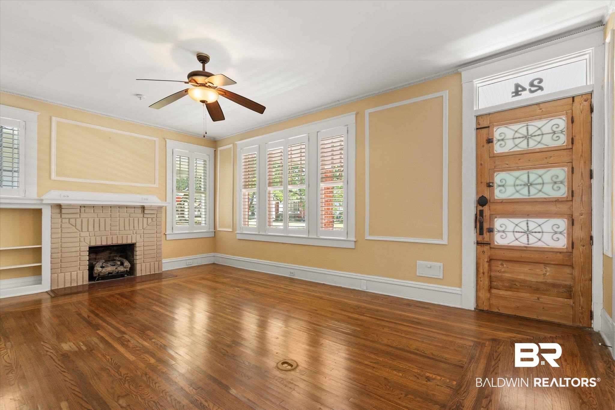 24 Macy Place Mobile, AL 36604 - Photo 6 of 38 Unfurnished living room with ceiling fan, plenty of natural light, a fireplace, wood finished floors, and crown molding