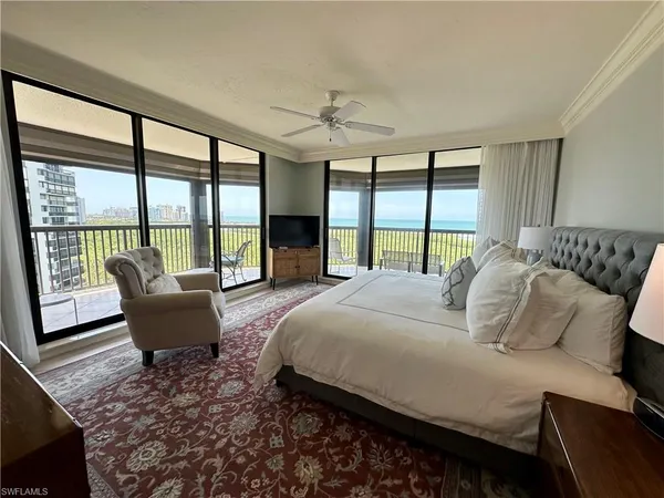 a bedroom with a bed and a large window