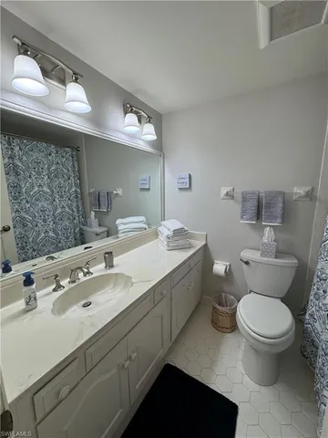 a bathroom with a double vanity sink toilet and a mirror