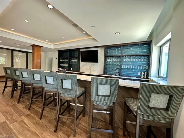 a kitchen with stainless steel appliances granite countertop a stove a sink a dining table and chairs with wooden floor