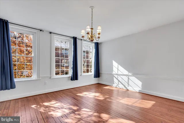 a view of a room with wooden floor chandelier and entryway