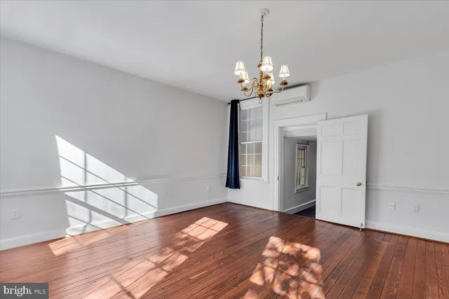 a view of a livingroom with a fireplace wooden floor and a window