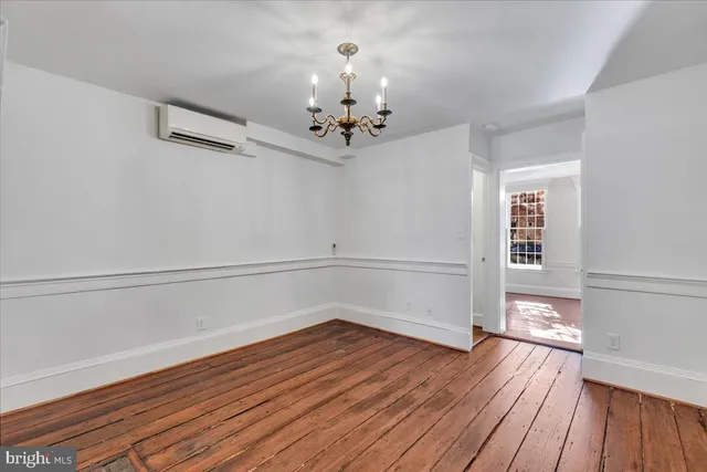 a view of a room with wooden floors and ceiling fan