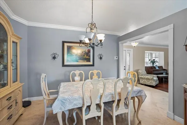 a dining room with furniture a chandelier and window