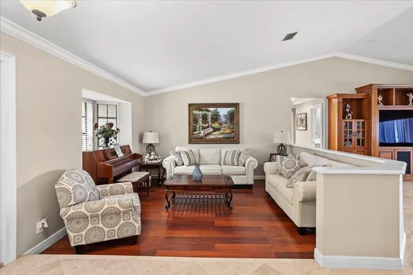 a living room with furniture and a wooden floor