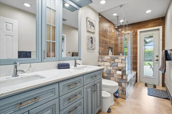 a spacious bathroom with a double vanity sink toilet and shower