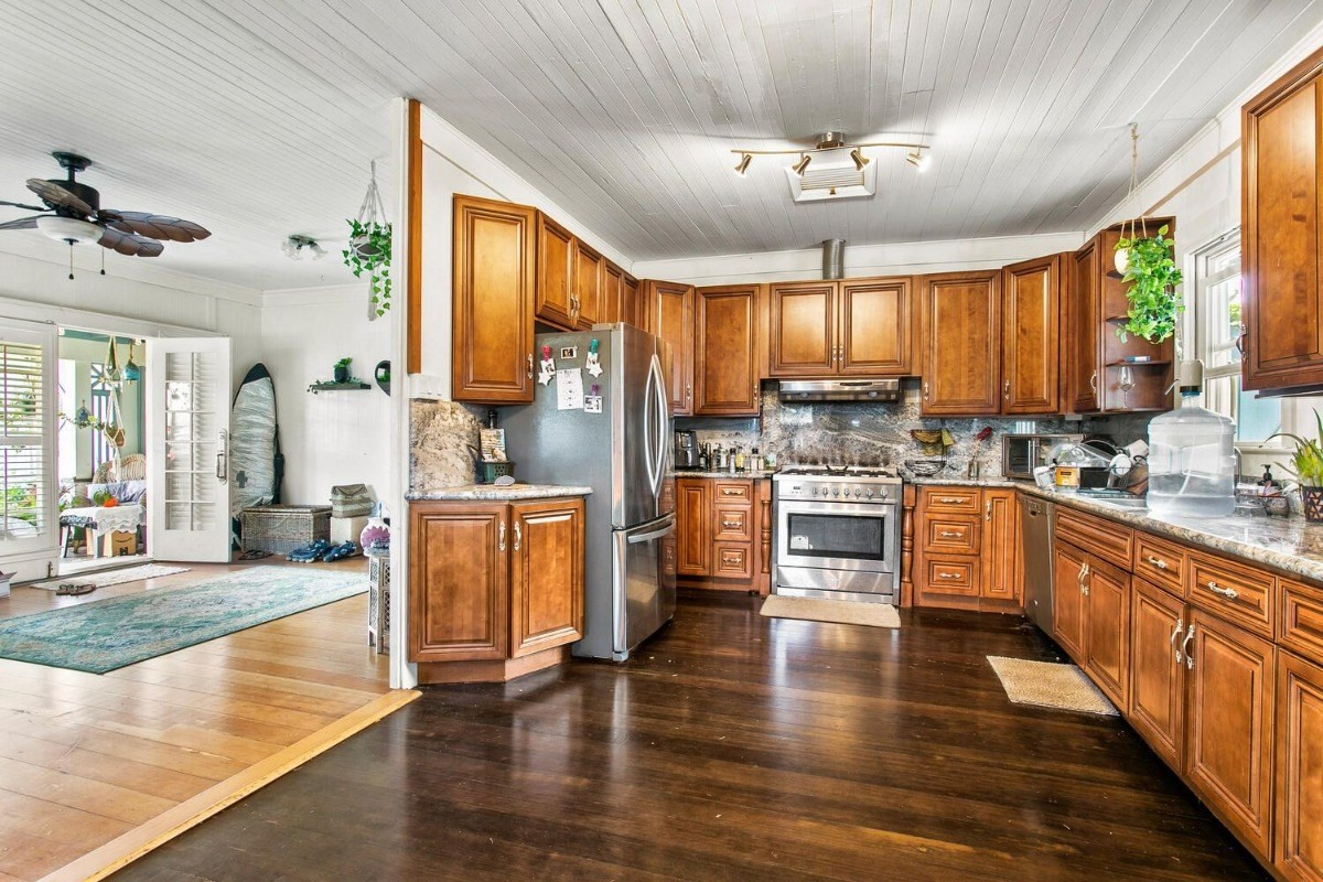 1054 Kealoha Road, Unit 2 Kapaa, HI 96746 - Photo 6 of 13 a kitchen with a refrigerator a stove cabinets and a dining table