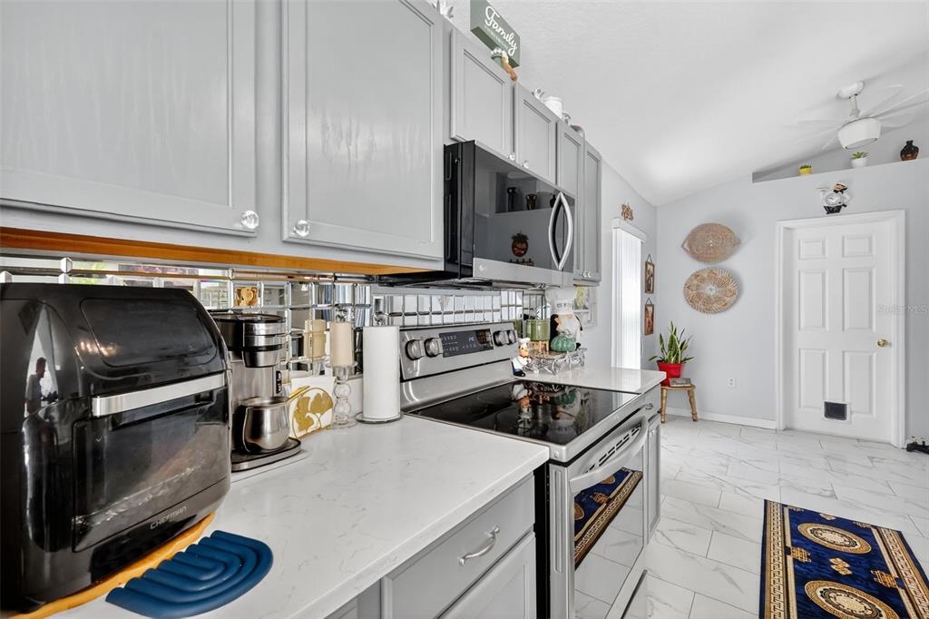 2442 Foxhollow Road Tavares, FL 32778 - Photo 13 of 28 a kitchen with stainless steel appliances a stove a microwave and a refrigerator