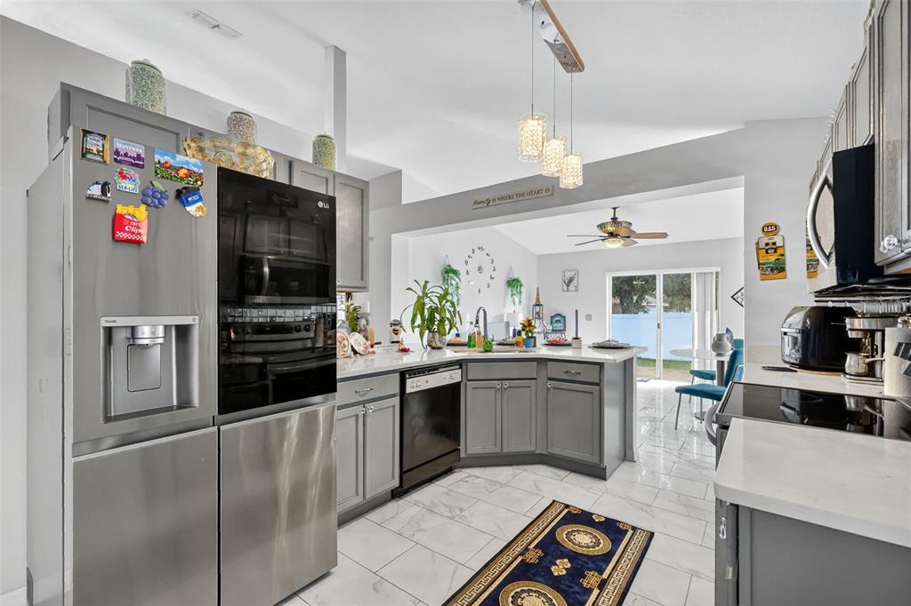 2442 Foxhollow Road Tavares, FL 32778 - Photo 14 of 28 a kitchen with stainless steel appliances kitchen island granite countertop a refrigerator and a sink