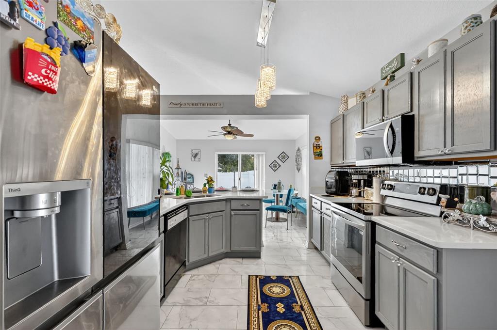 2442 Foxhollow Road Tavares, FL 32778 - Photo 16 of 28 a kitchen with stainless steel appliances kitchen island granite countertop a sink stove and refrigerator