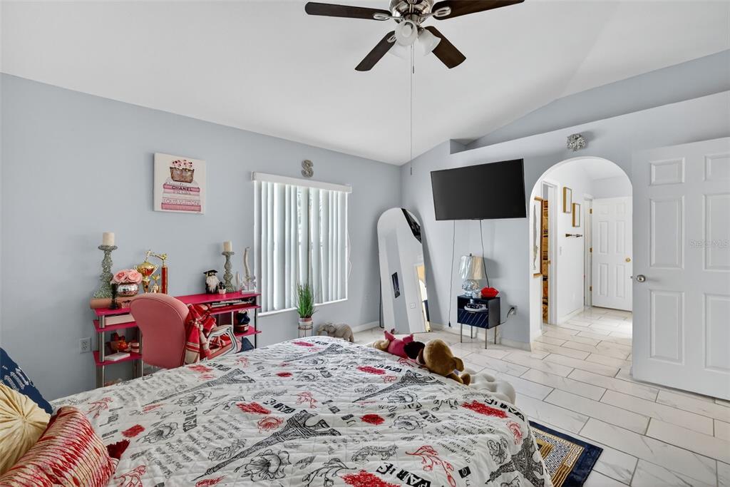 2442 Foxhollow Road Tavares, FL 32778 - Photo 24 of 28 a bed room with a bed mirror and a flat tv screen