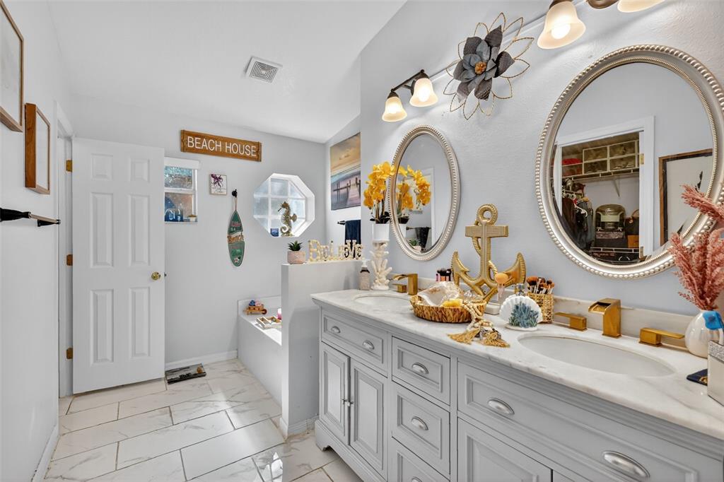 2442 Foxhollow Road Tavares, FL 32778 - Photo 28 of 28 a bathroom with a granite countertop double vanity sinks and a mirror