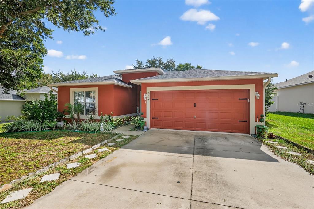 2442 Foxhollow Road Tavares, FL 32778 - Photo 3 of 28 a view of a house with a yard and garage
