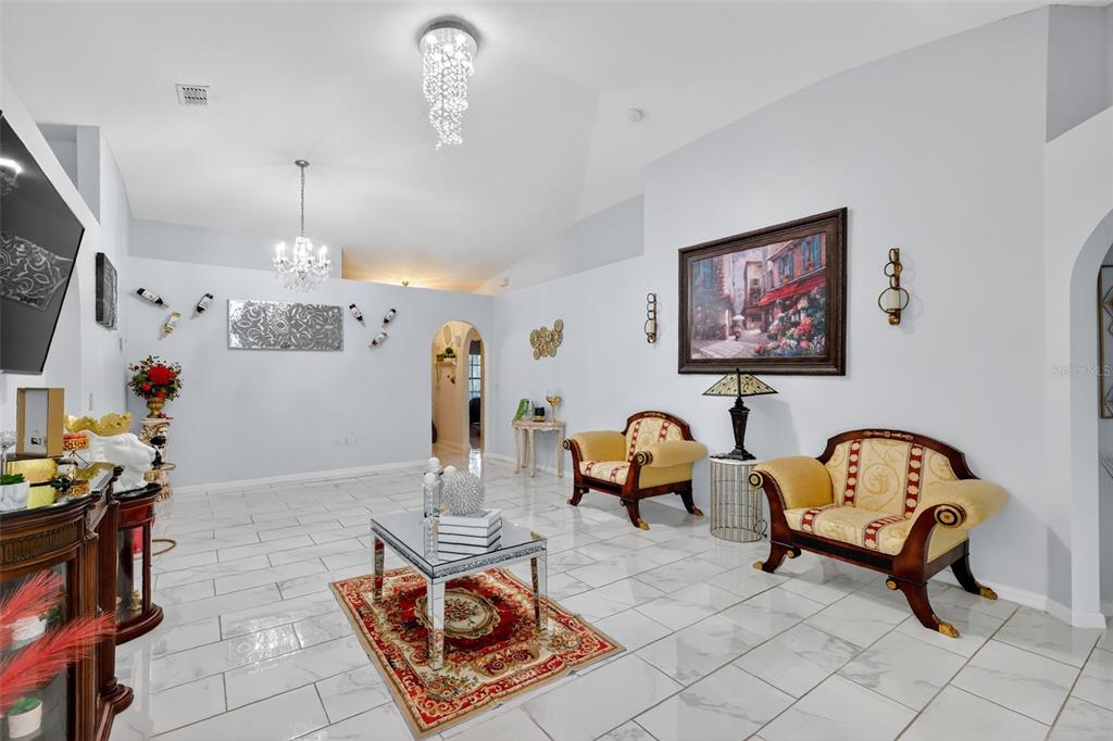 2442 Foxhollow Road Tavares, FL 32778 - Photo 9 of 28 a living room with furniture and a chandelier