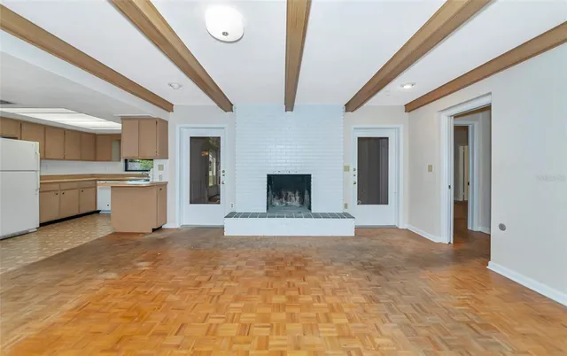 a view of a kitchen with a sink and an empty room