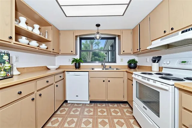 a kitchen with granite countertop a sink stainless steel appliances and cabinets