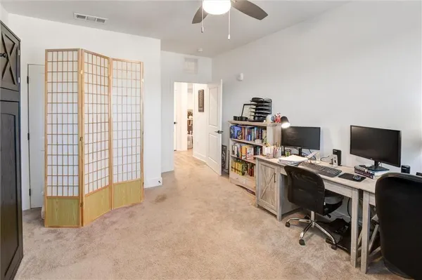 a spacious bedroom with a bed a couch and a chandelier