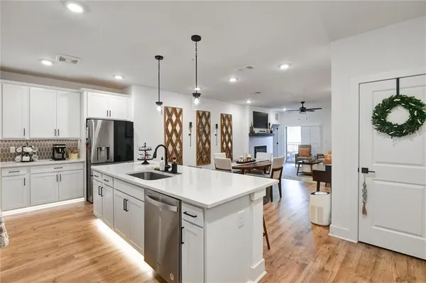 a kitchen with a dining table chairs stainless steel appliances and cabinets