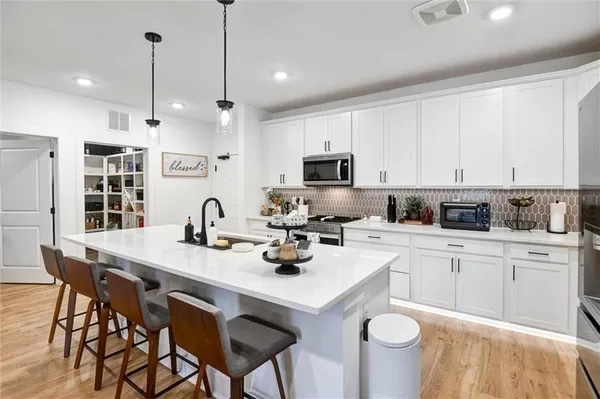 a kitchen with sink stove and chairs