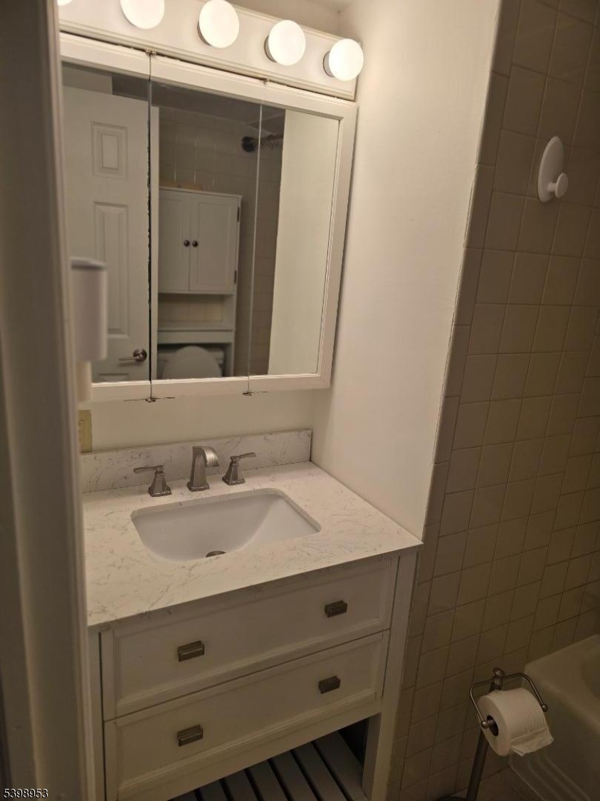 18 Donna Drive, Unit 2 Wood-Ridge, NJ 07075 - Photo 8 of 15 a bathroom with a sink and a mirror