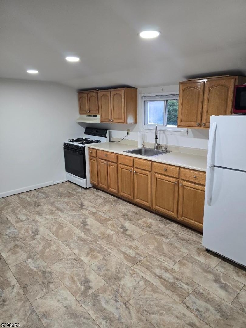 18 Donna Drive, Unit 2 Wood-Ridge, NJ 07075 - Photo 10 of 15 a kitchen with stainless steel appliances granite countertop a refrigerator sink and cabinets