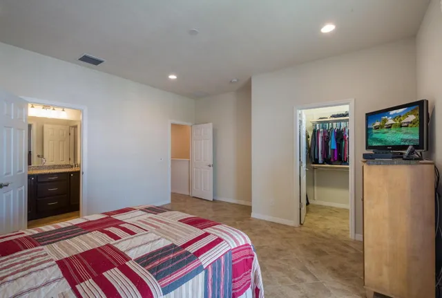 a bedroom with a bed and a flat screen tv
