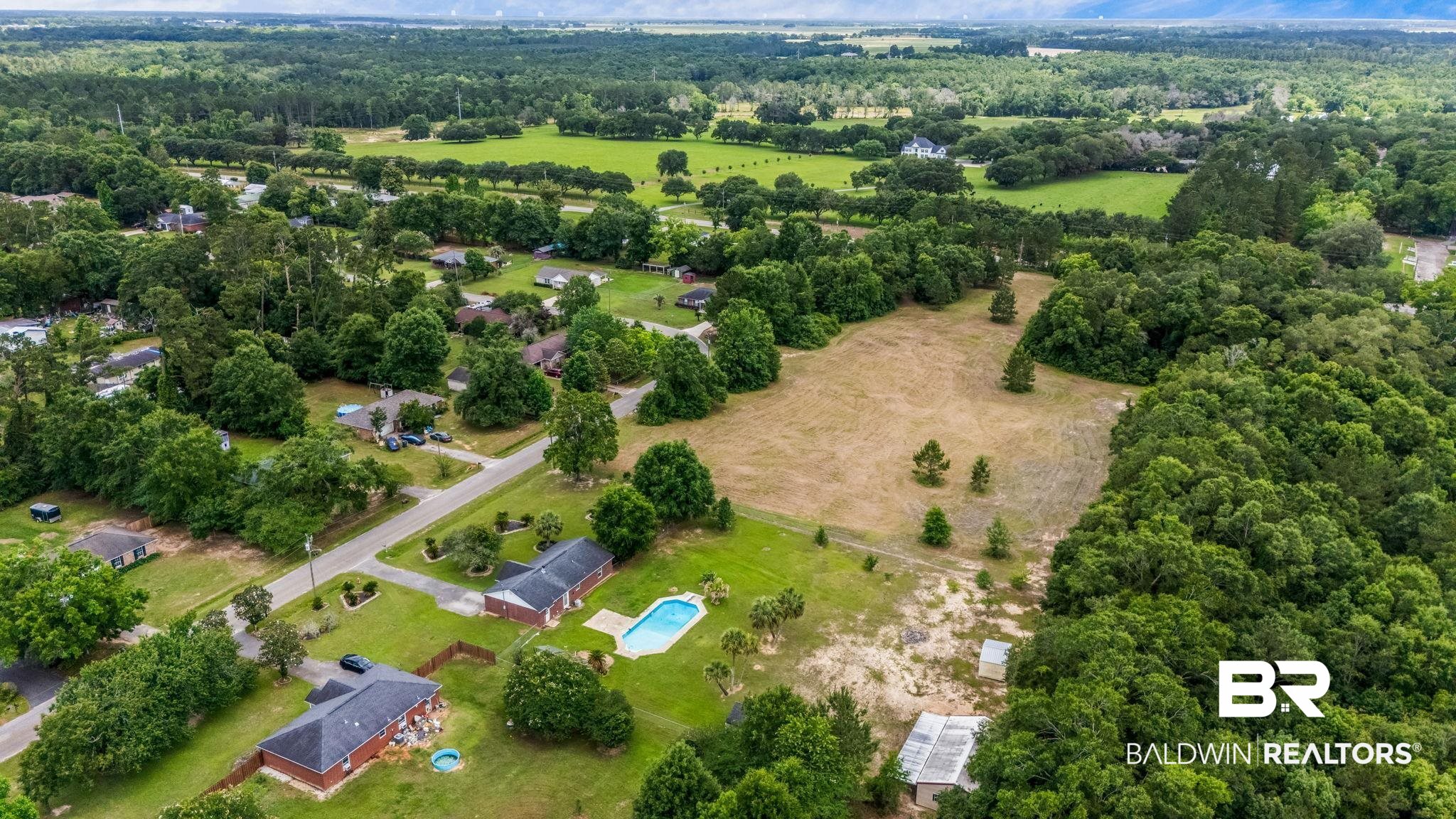15096 Highland Circle Foley, AL 36535 - Photo 47 of 52 Aerial perspective showcasing a residential area amidst expansive green landscapes and forested sections