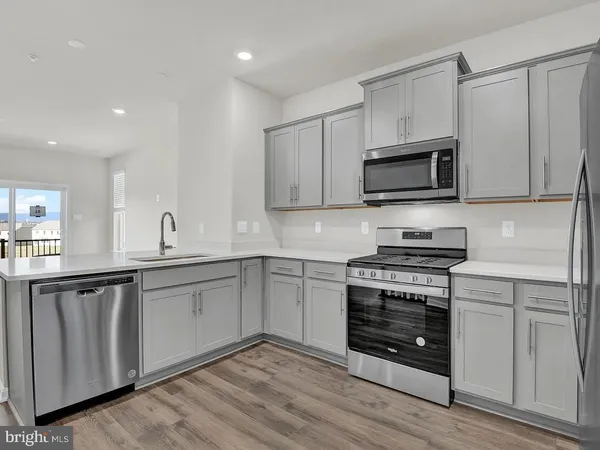 a kitchen with a refrigerator and white cabinets