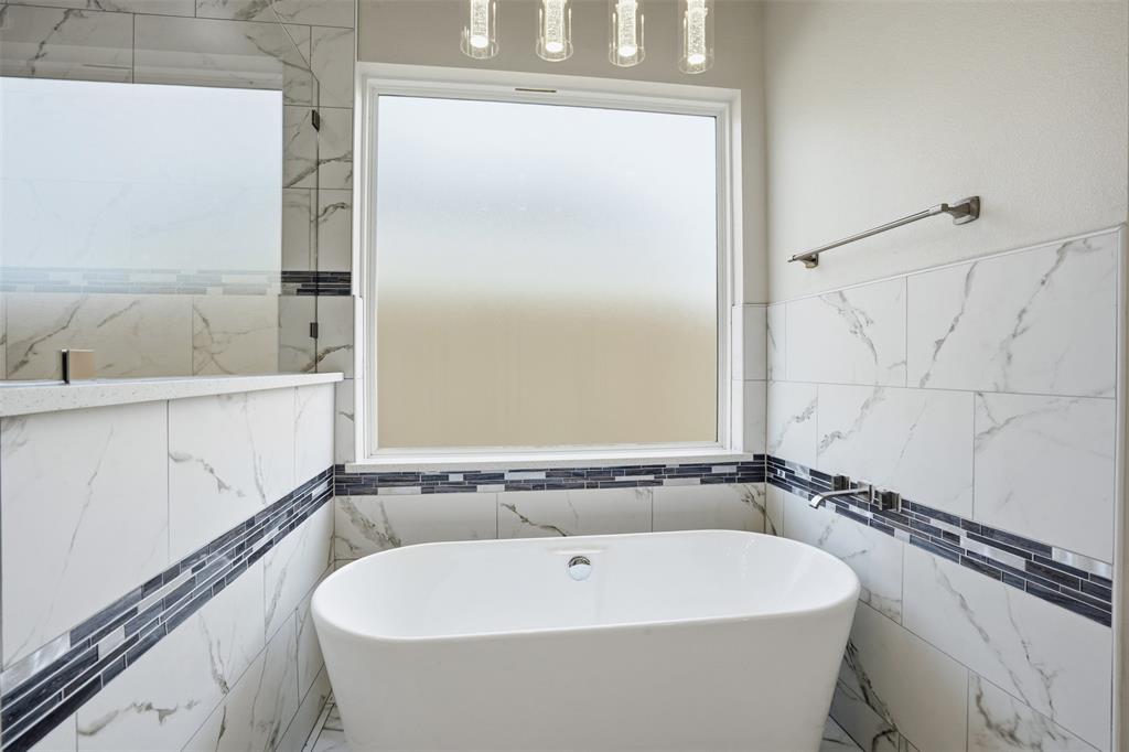 532 Highview Court Godley, TX 76044 - Photo 16 of 39 Freestanding soaking tub set against a tiled accent wall featuring a frosted window and mosaic border