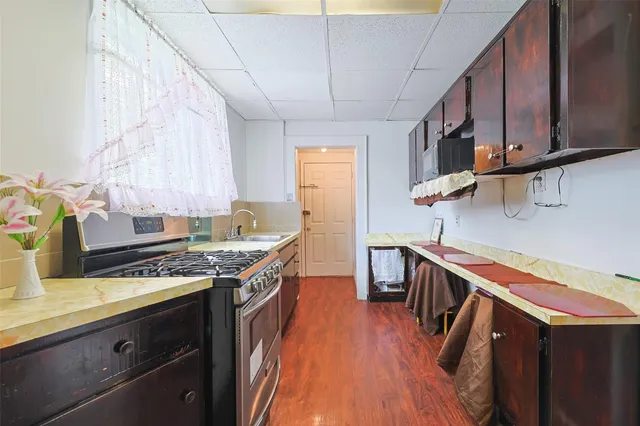 a kitchen with stainless steel appliances granite countertop a sink a stove and a wooden floors