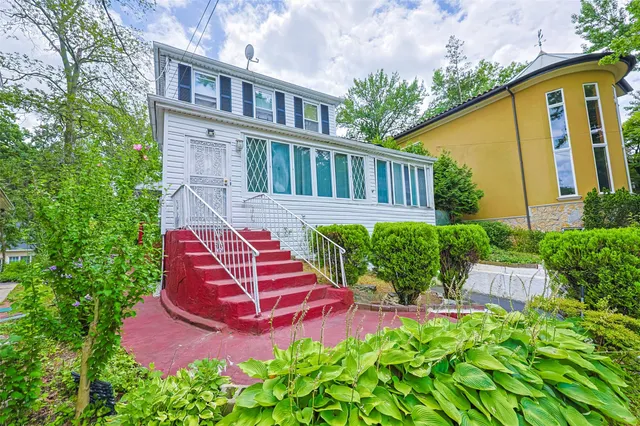 a view of a house with potted plants and a bench in it