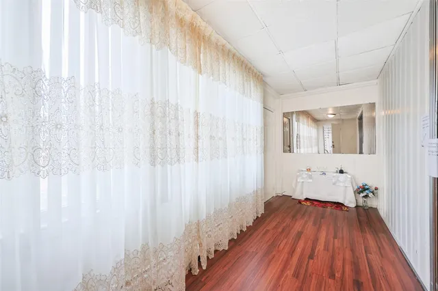 a view of a room with wooden floor and bench